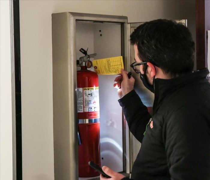 Technician checking fire extinguisher